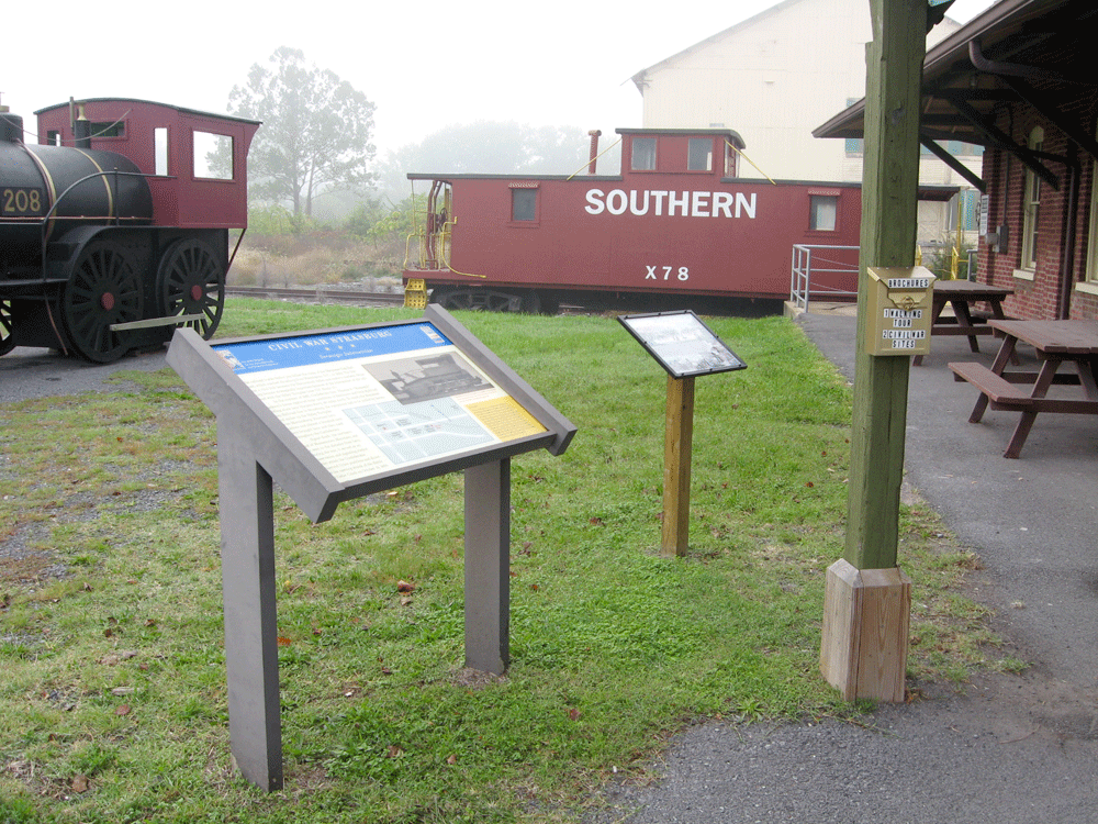 The marker for The Great Train Raid is east of the Museum next to a wayside marker on Civil War Strasburg - Strategic Intersection